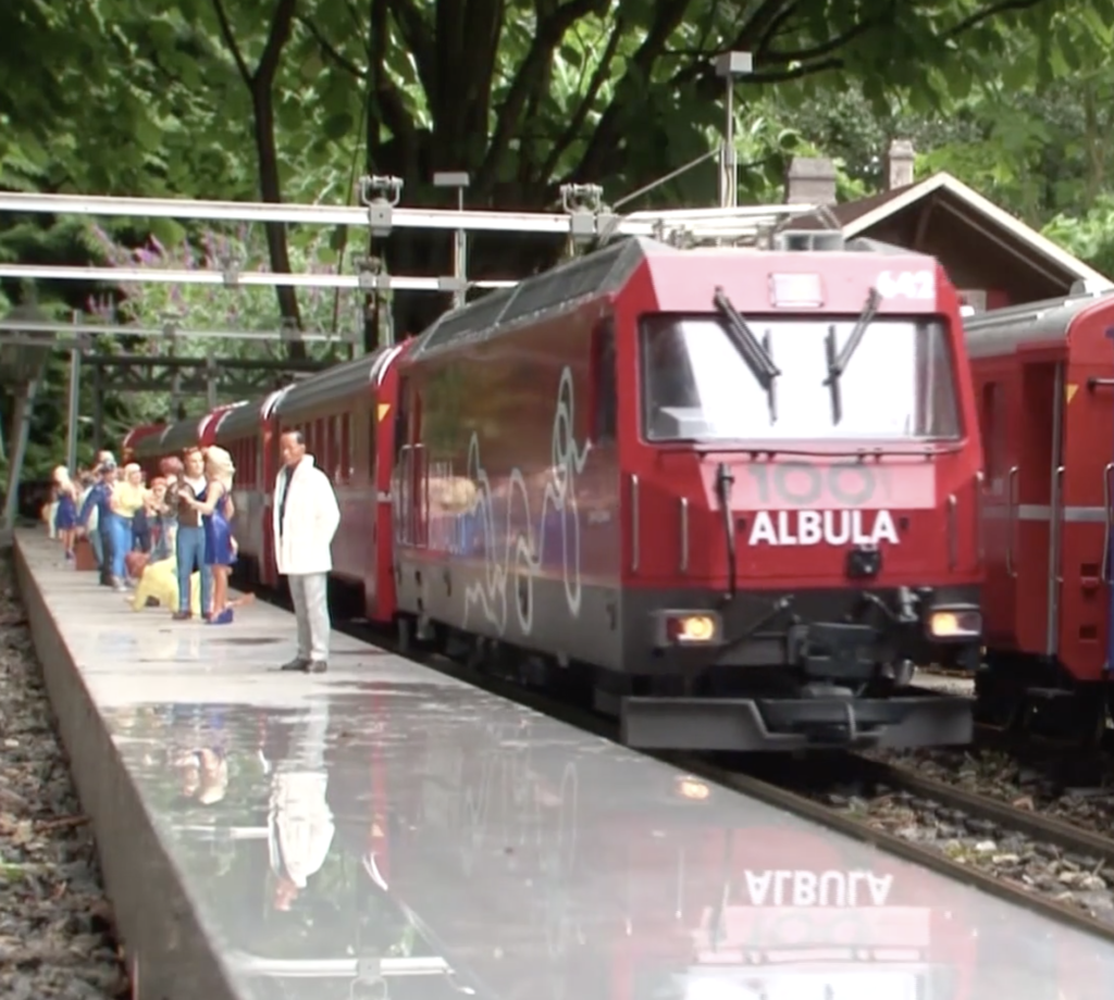 A red Swiss narrow gauge train.