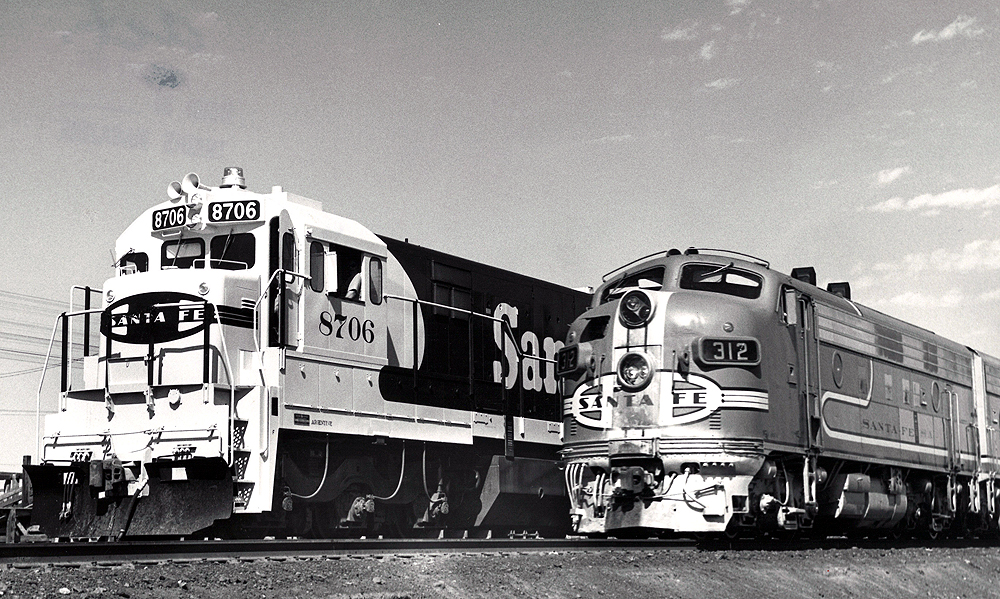 Two santa fe trains side by side on the tracks