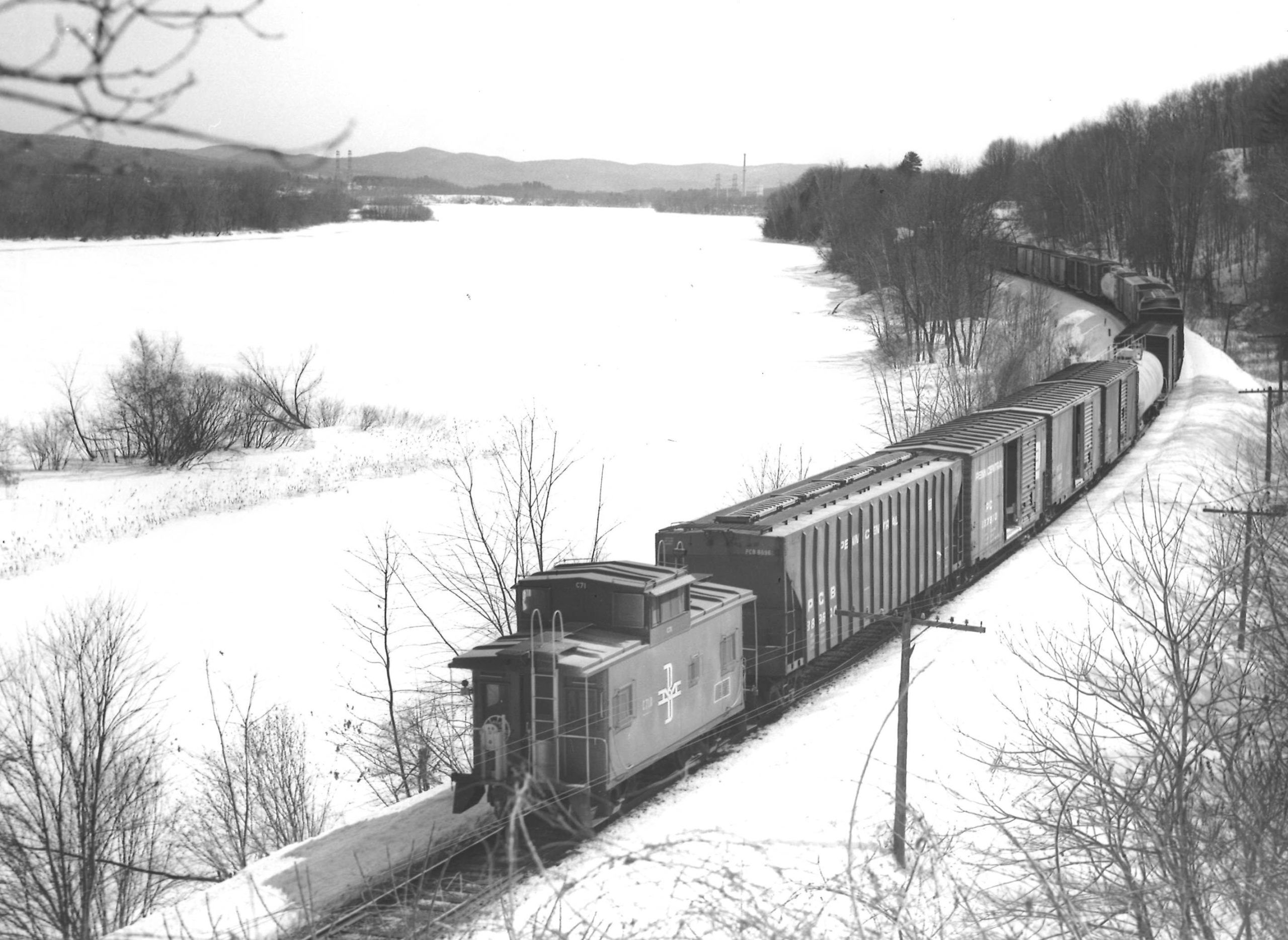 a freight train going off into the distance with a caboose in the foreground on a winter day