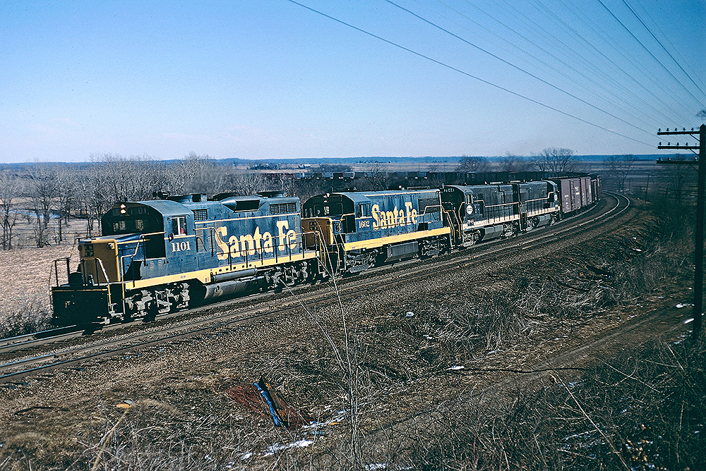 A navy blue and yellow Santa Fe locomotive on the tracks