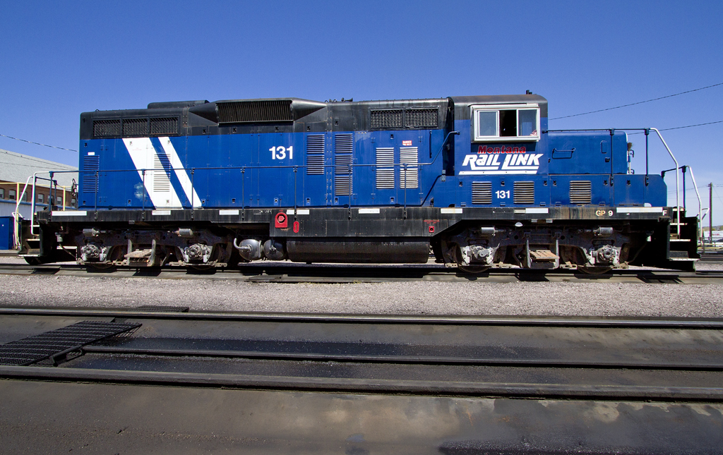 A blue train sitting on the tracks
