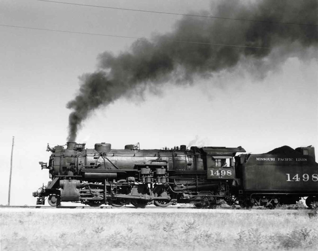Smoking steam Missouri Pacific locomotives with freight train