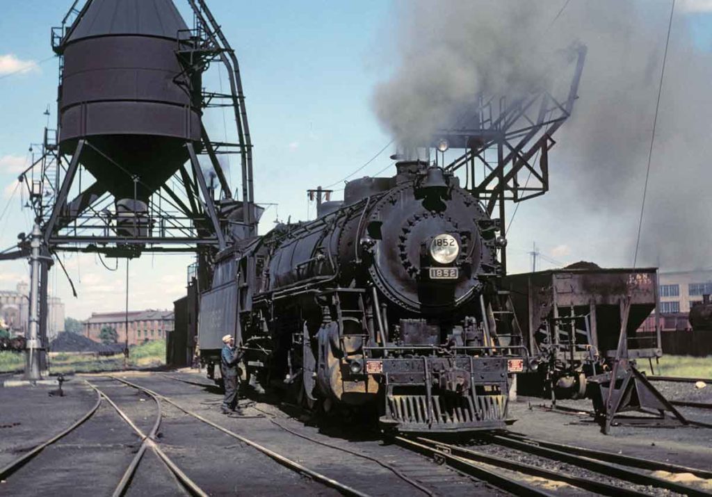 Stationary steam locomotive underneath coaling tower