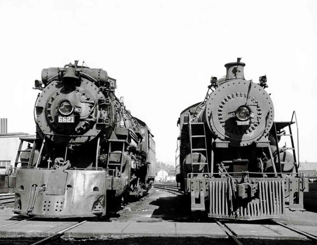 Smoking steam Frisco and Missouri Pacific locomotives at service tracks