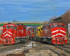 Two trains side by side under a bridge