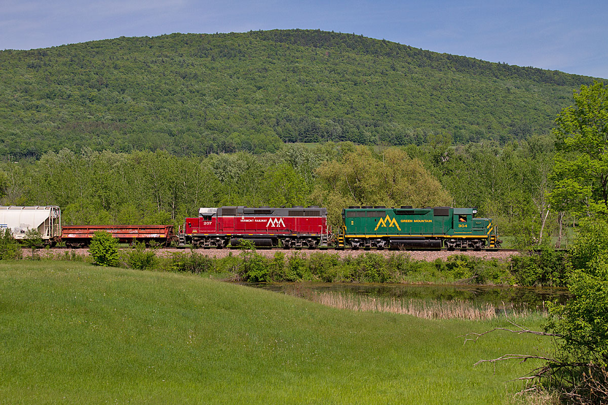 A train passing through a hilly, grassy, area