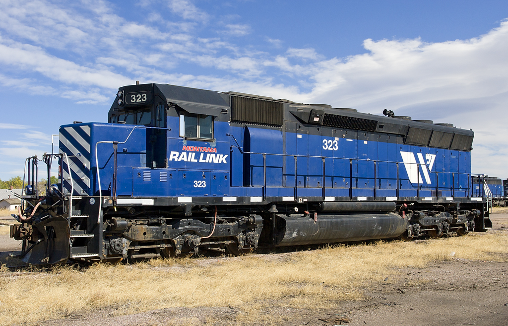 A blue train sitting on the tracks