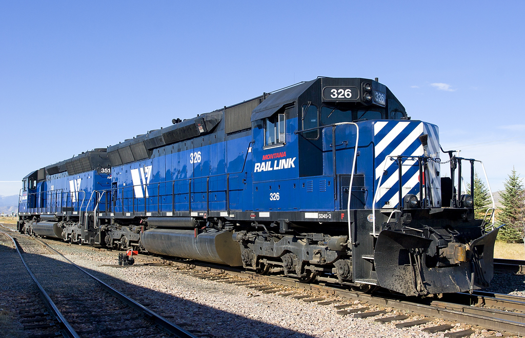 A blue train sitting on the tracks