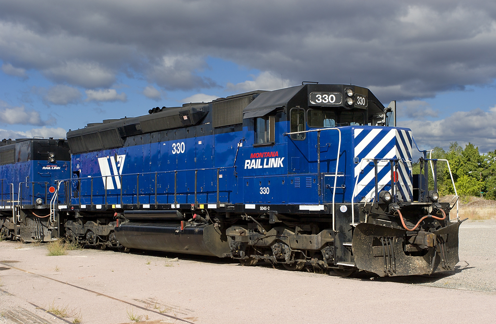 A blue train parked on a cloudy day