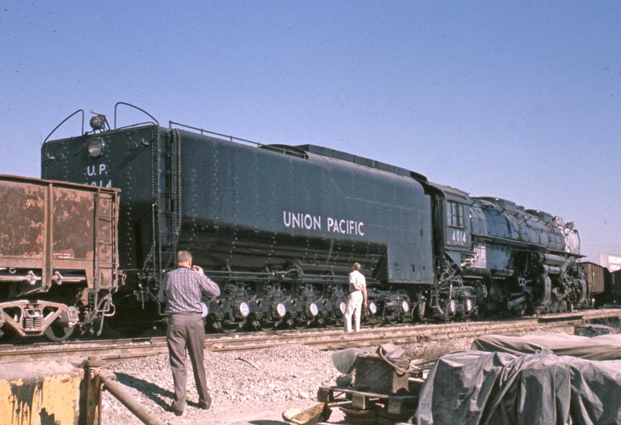 Someone looking up at the Big Boy train as someone else takes their picture