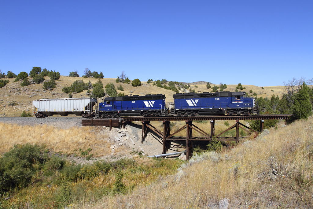 A blue train passing over a bridge