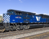 A blue train sitting on the tracks