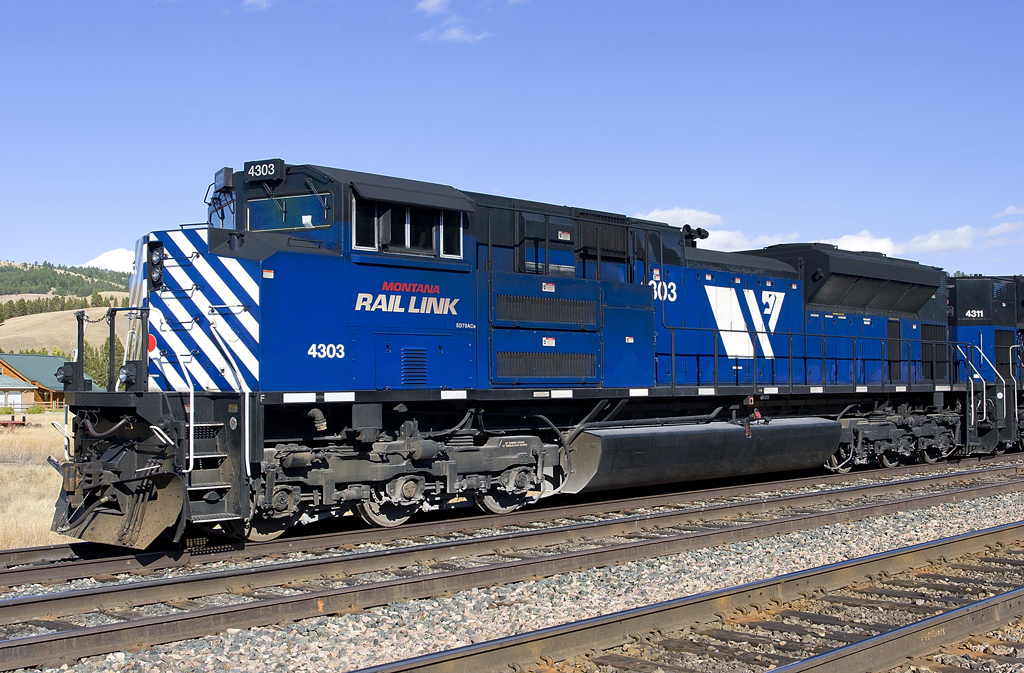 A blue train sitting on the tracks