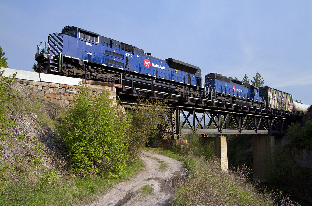 A blue train passing over a bridge