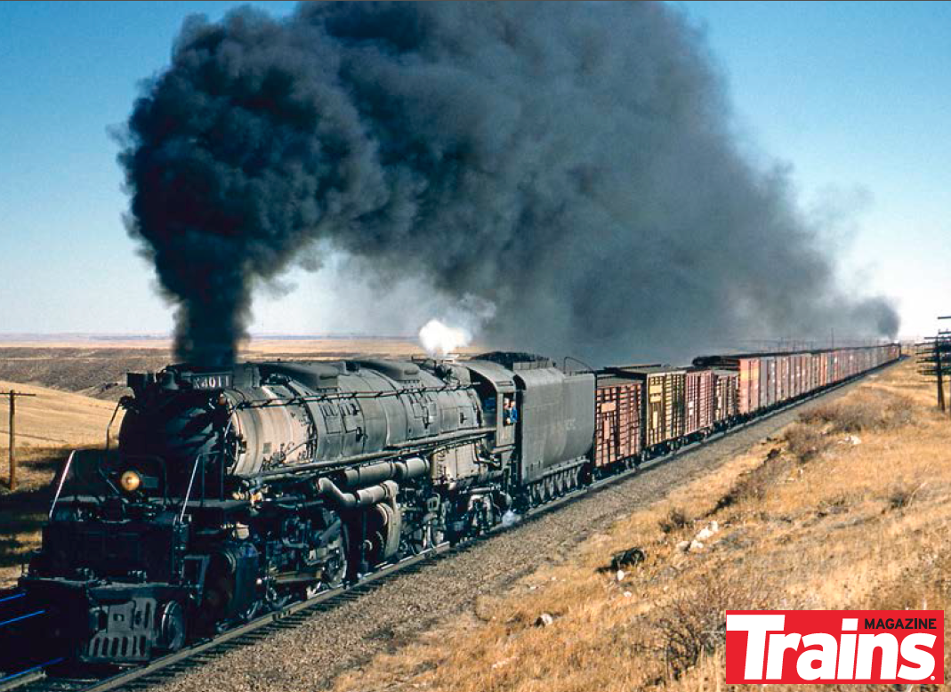 Smoking steam locomotive with freight train in shallow cut