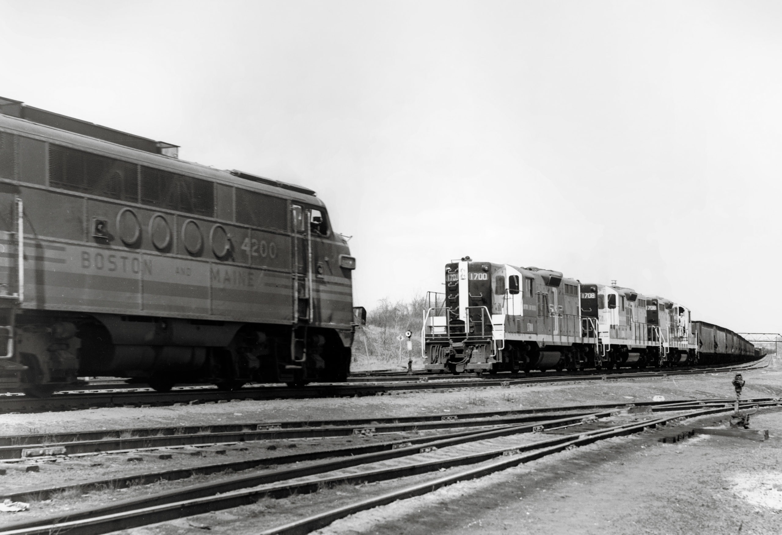 a freight train in the background approaching a diesel in the foreground