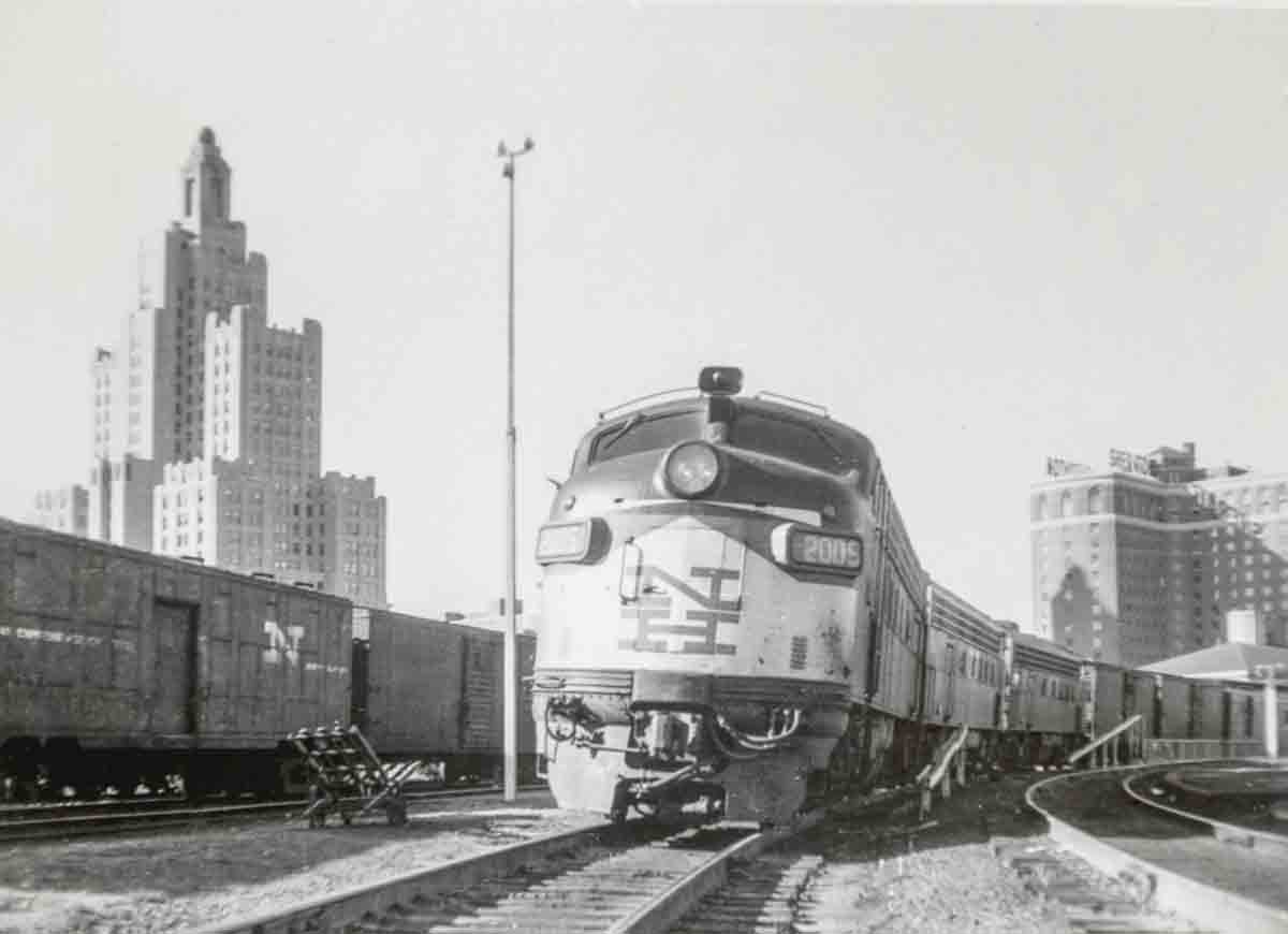 Passenger train in station surrounded by downtown high rises