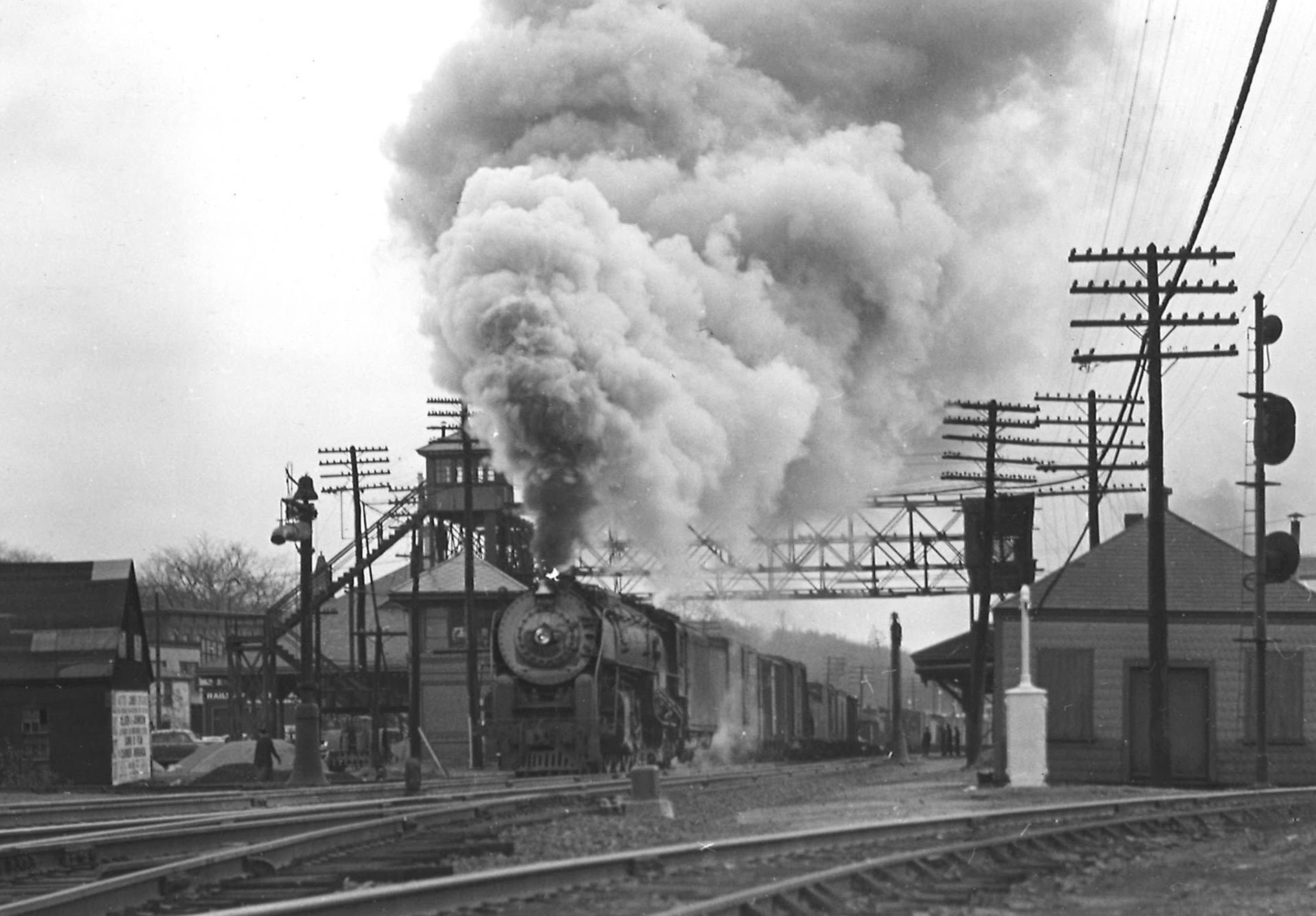 a steam engine pulling freight with a huge plume of smoke