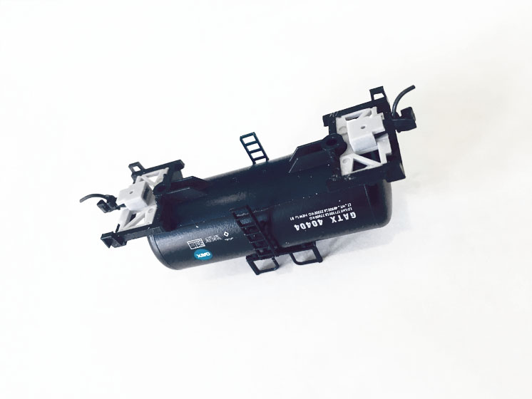 Simplifying body-mounted couplers: A model tank car turned onto its back with trucks removed