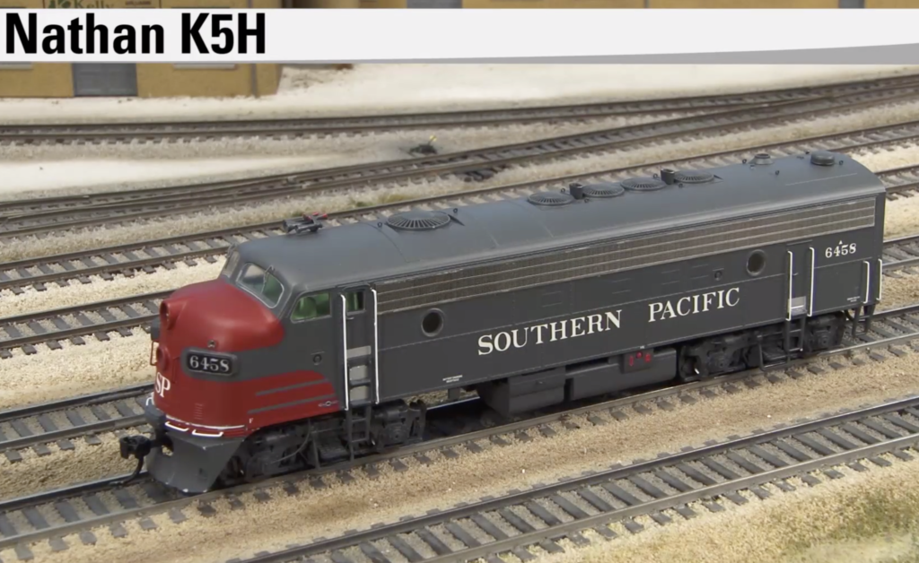 Gray cab unit type diesel locomotive model shown on in an unfinished rail yard.