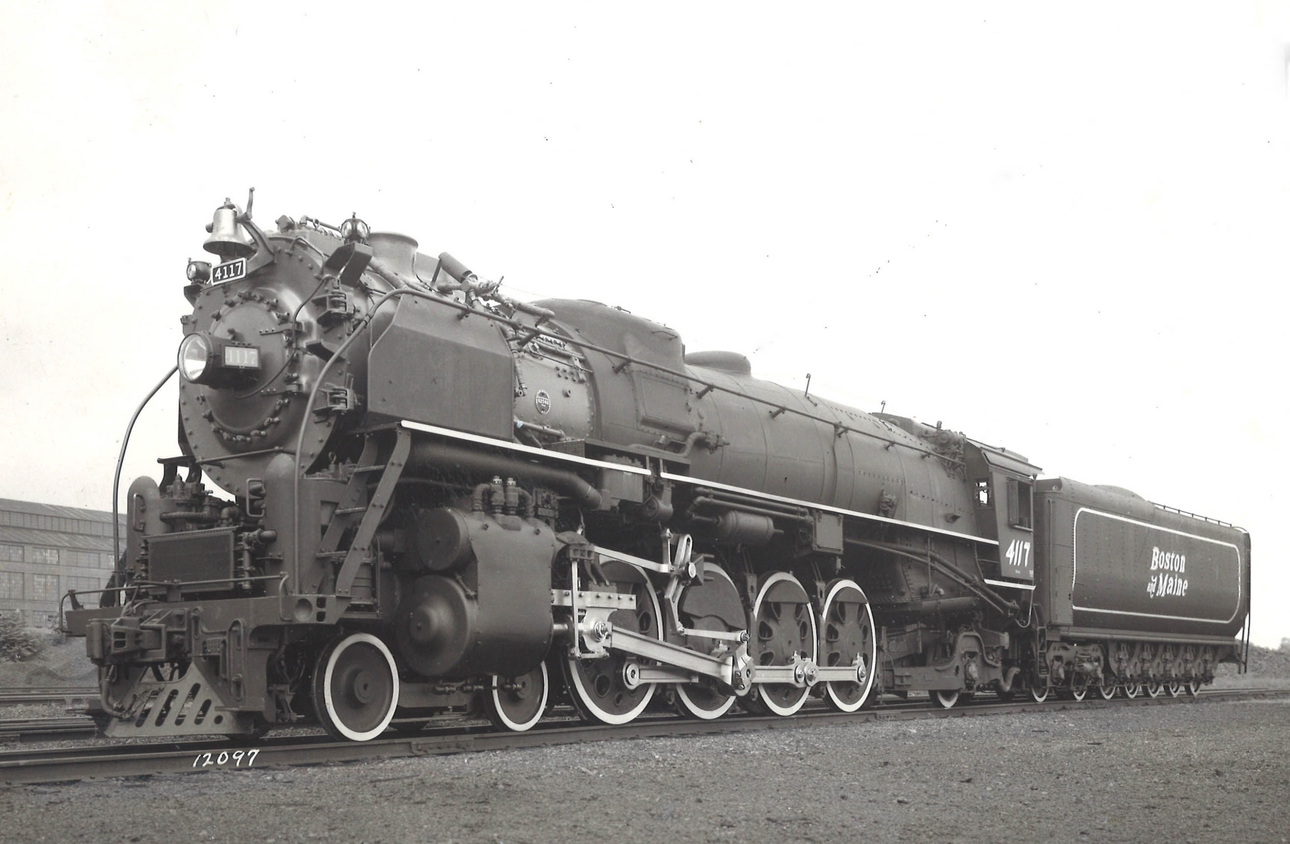 A close up black and white photo of a Mountain-type locomotive sitting on the tracks