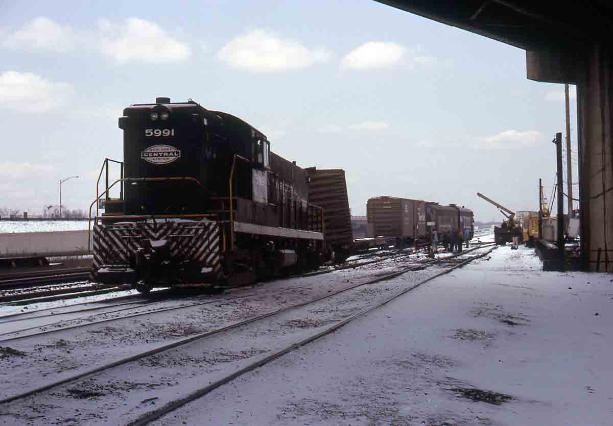 Black diesel locomotive with derailed train in snow