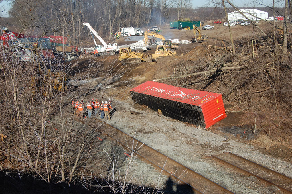 Workers looking at a knocked over container