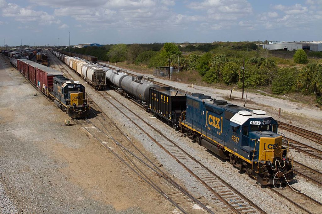 Train with blue and yellow locomotive in yard