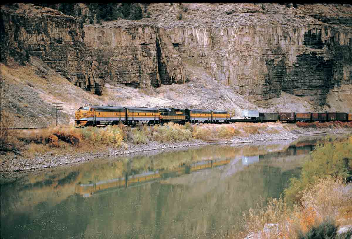 Five diesel locomotives with freight train along river