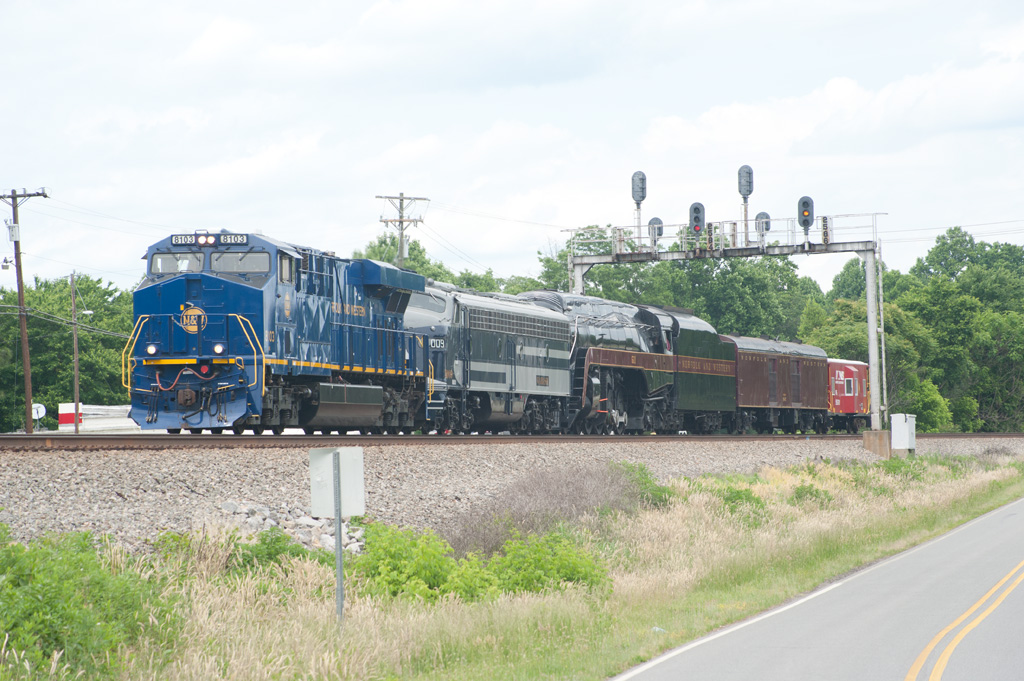 A train passing below a stoplight