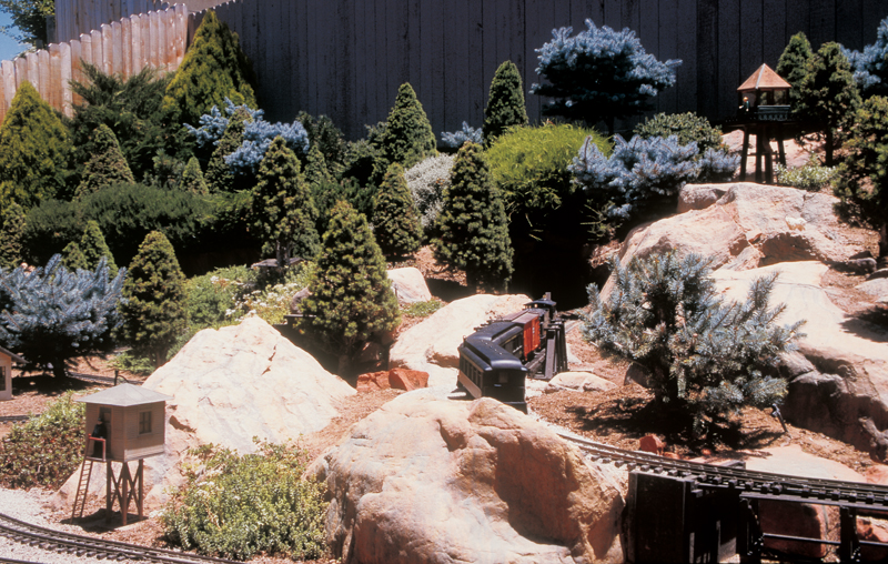 garden railway with lots of rocks and conifers