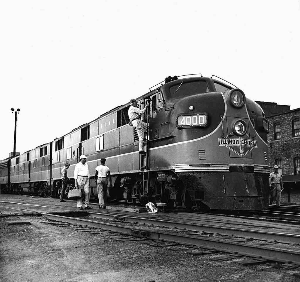 a diesel passenger train with a crew disembarking and embarking