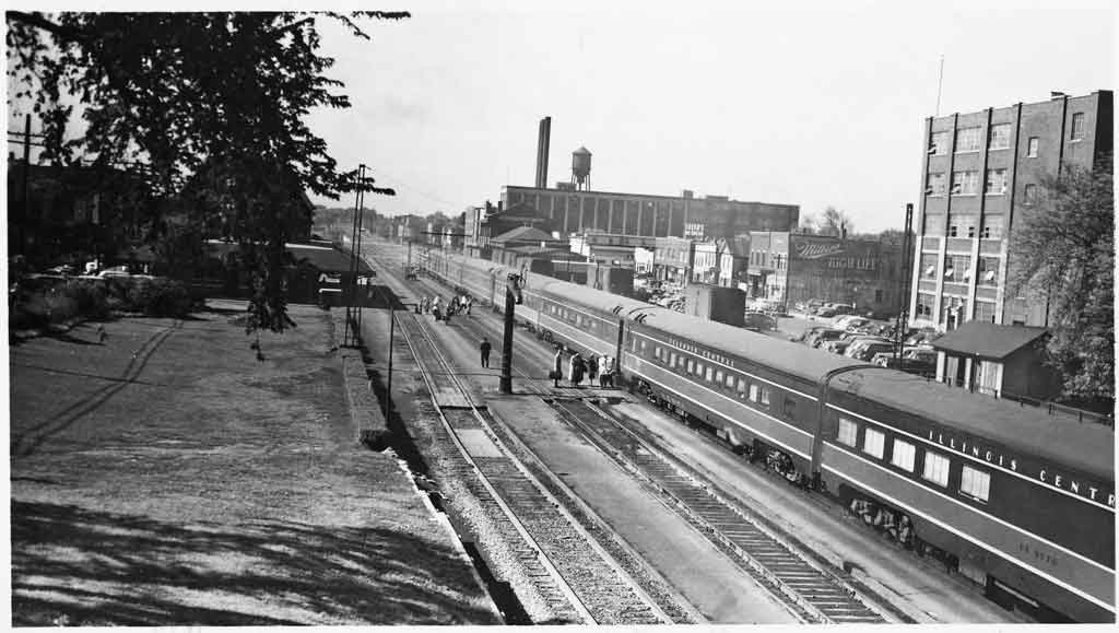 a passenger train by some buildings