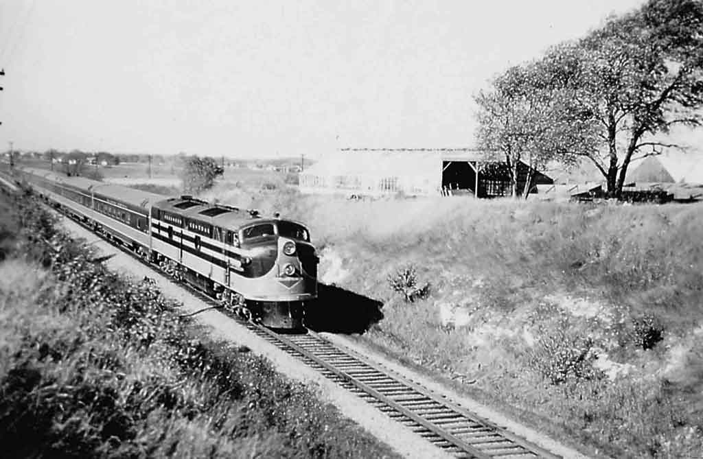 a diesel passenger train by a field