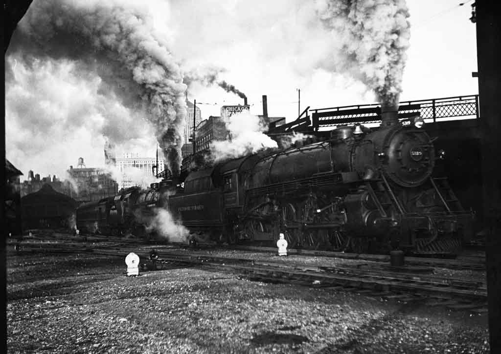A black and white photo of a train with a lot of smoke coming out of its chimney