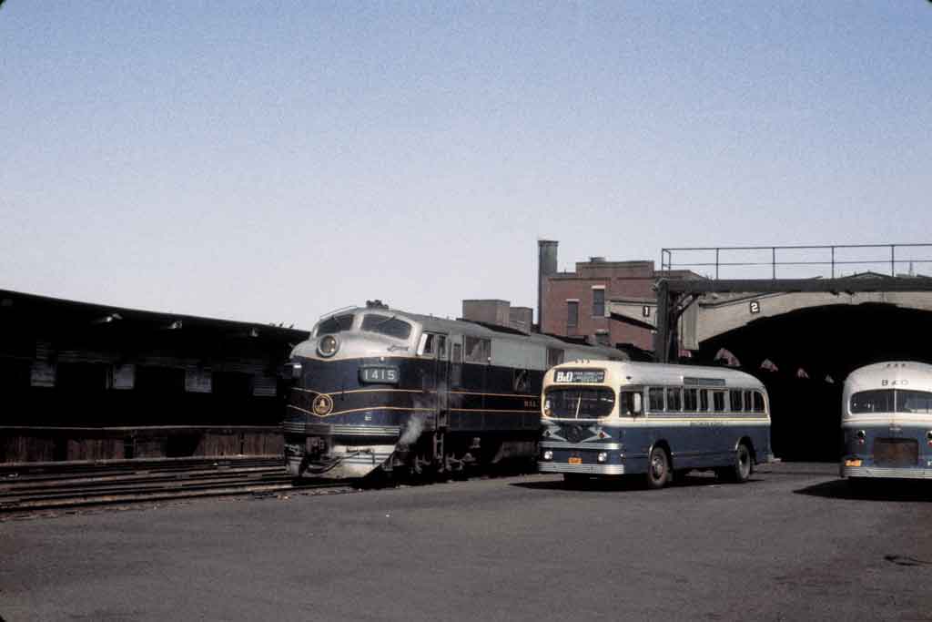 A train next to two buses