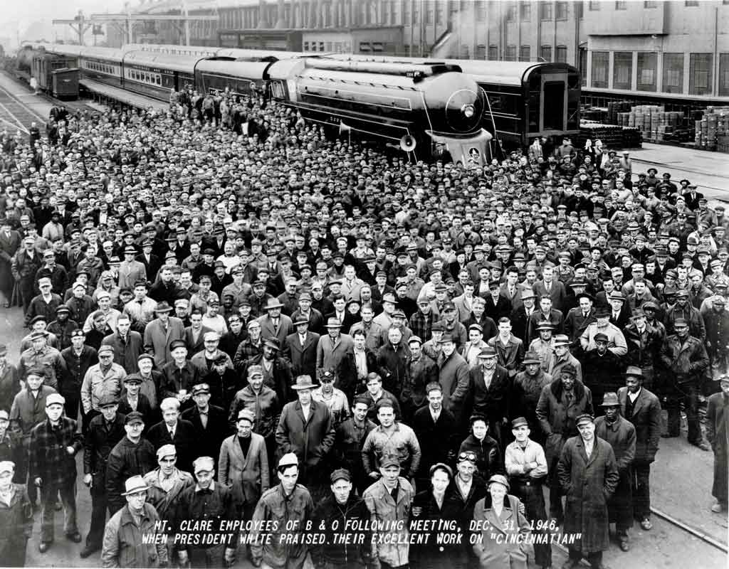 A black and white giant group photo taken in front of a train