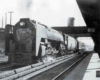 a steam locomotive passenger train at a depot