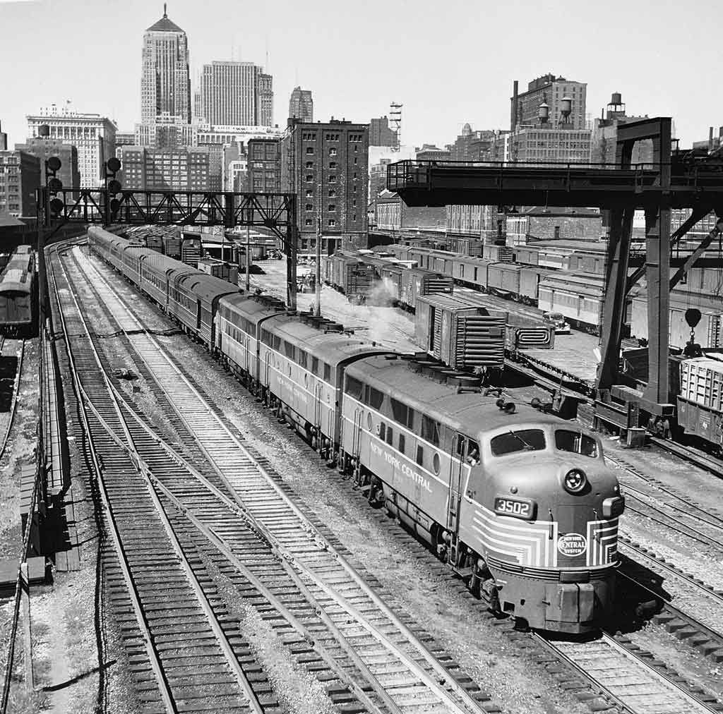 a diesel train departing a station in the background