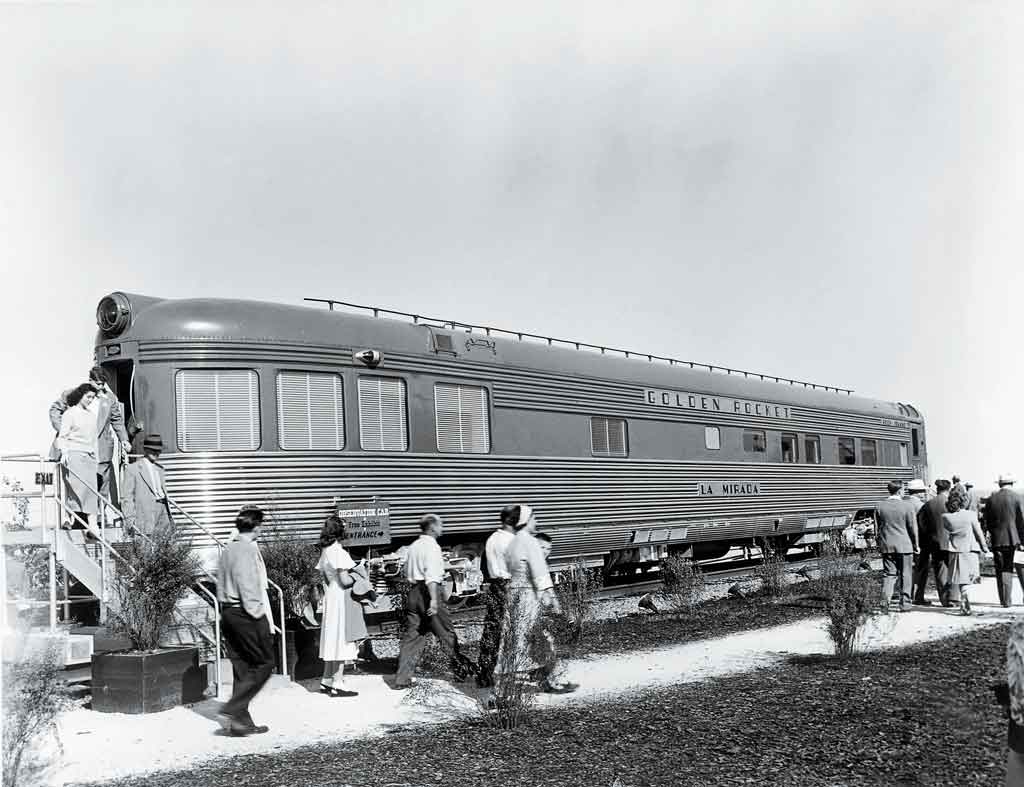 A black and white photo of passengers getting off a locomotive