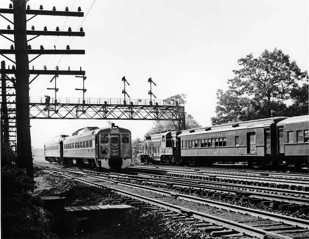 A black and white photo of two commuter trains passing each other