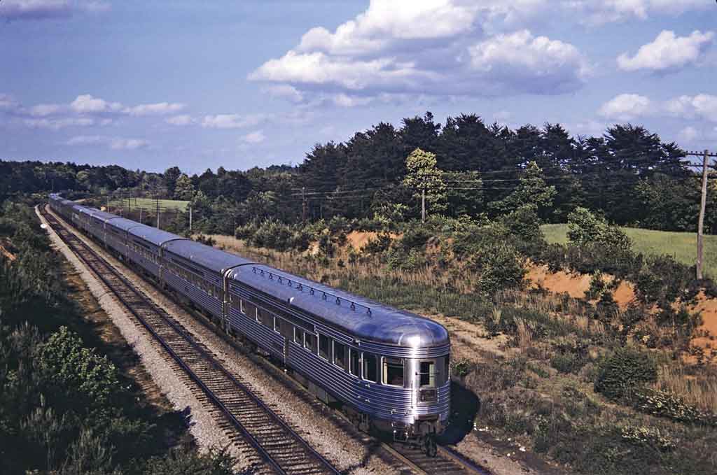A locomotive moving past trees