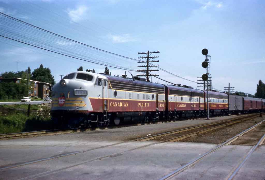 Three diesel locomotives pull passenger train by signal