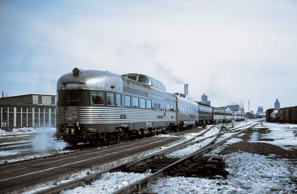 A train departing a city on a cold winter day