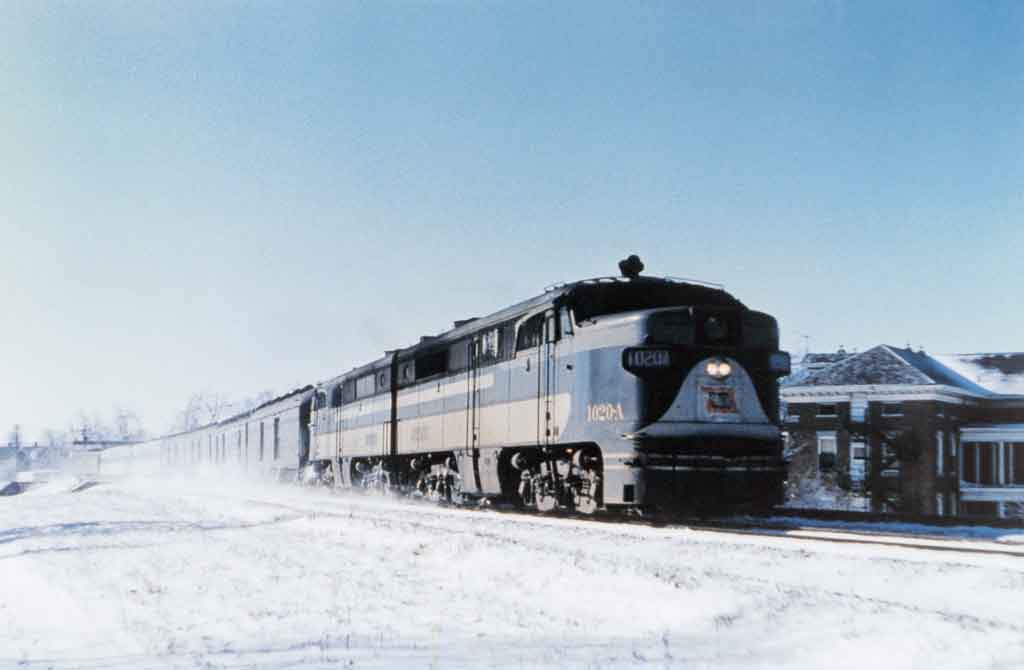 A locomotive travelling through a snowy city