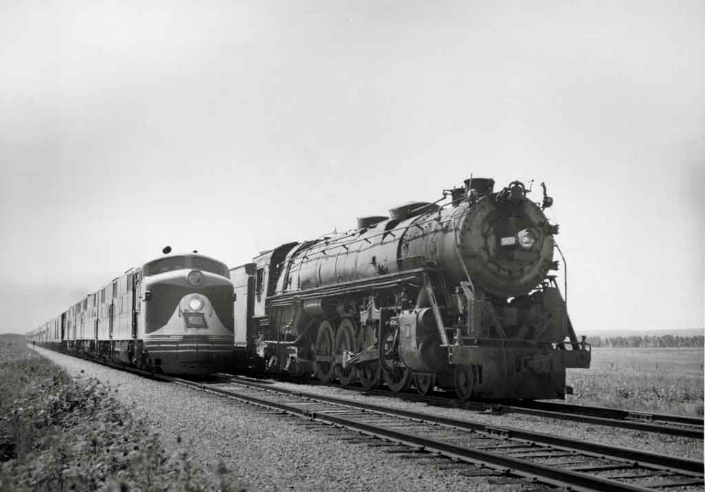 A black and white photo of two locomotives travelling side by side