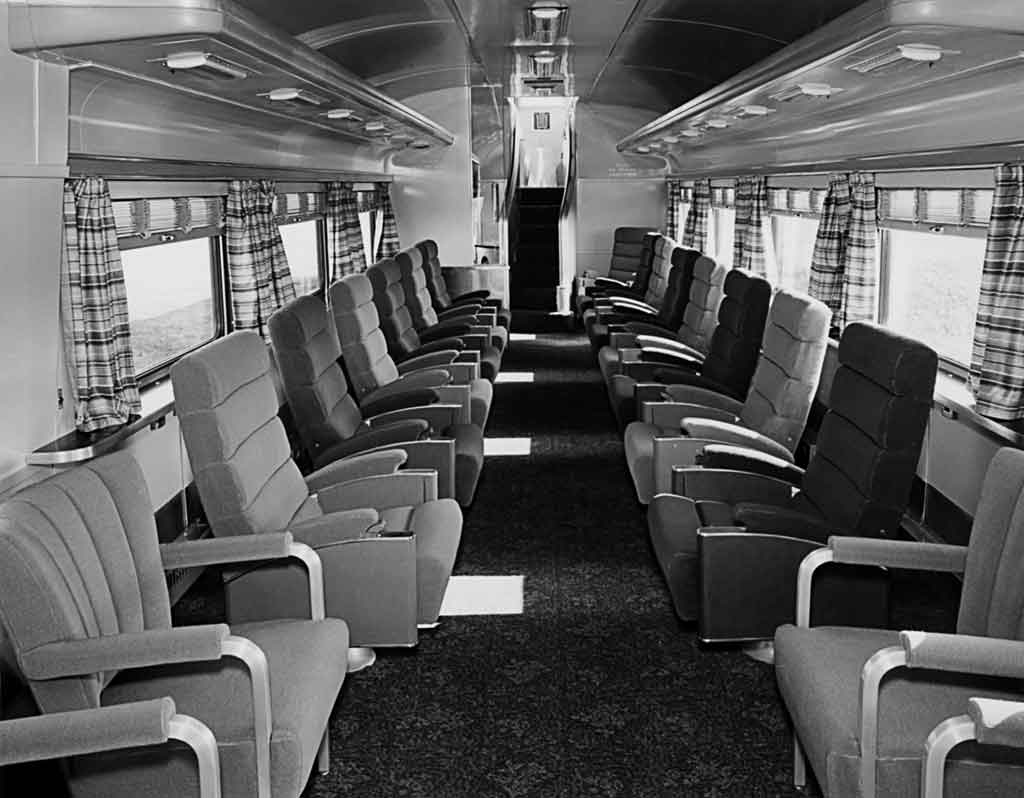 A black and white picture of empty seats inside a train
