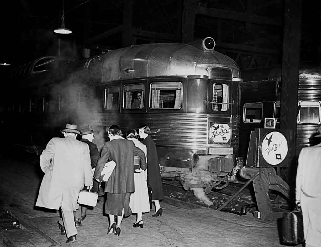 A black and white photo of passengers boarding a train