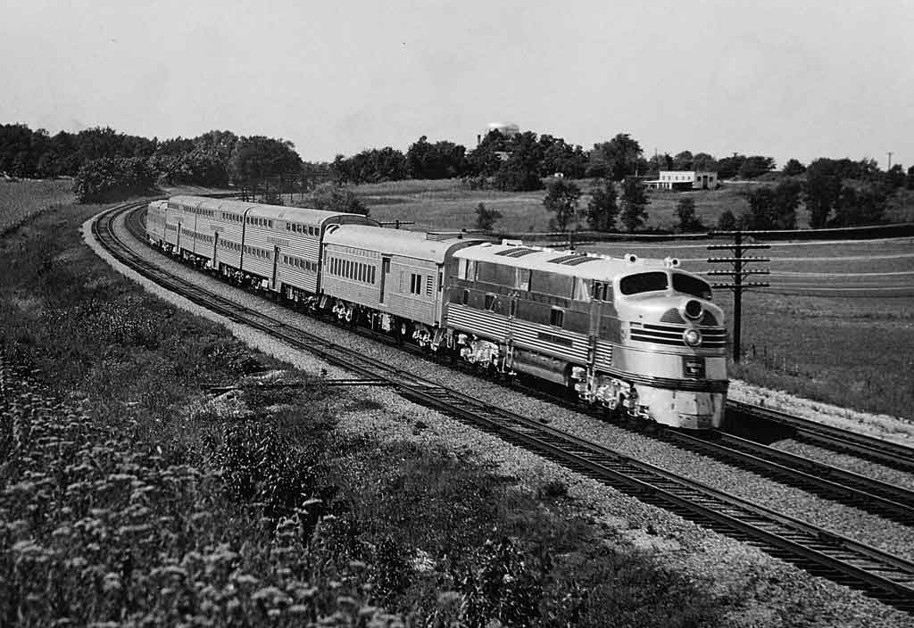 A black and white photo of a train turning a corner