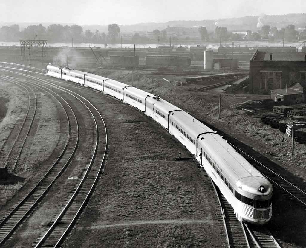 A black and white overhead shot of a train turning a corner